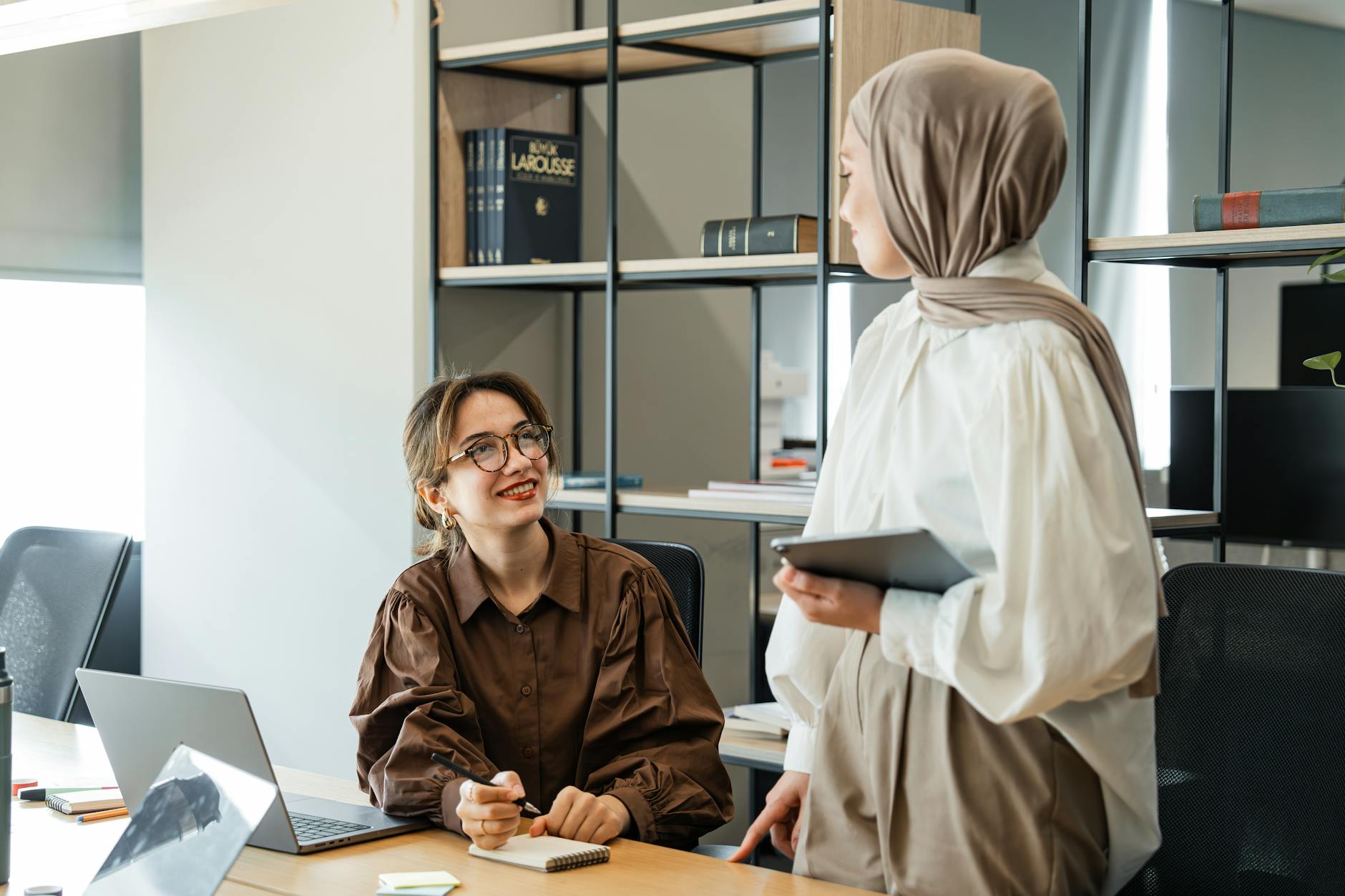 https://www.pexels.com/photo/two-women-in-an-office-interior-with-shelves-20450962/